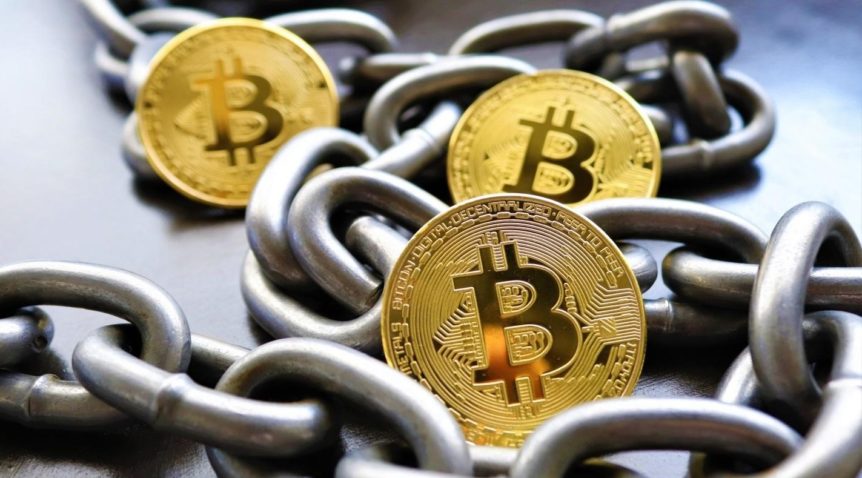 Gold Bitcoins surrounded by metal chains