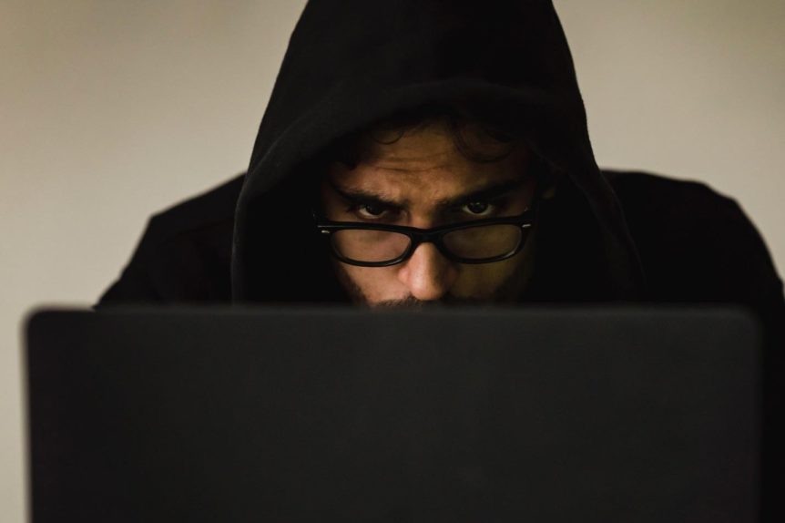 man in a hoodie using a laptop