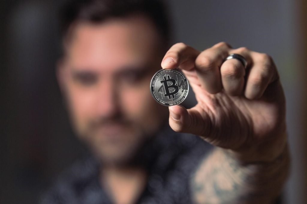 person holding silver Bitcoin
