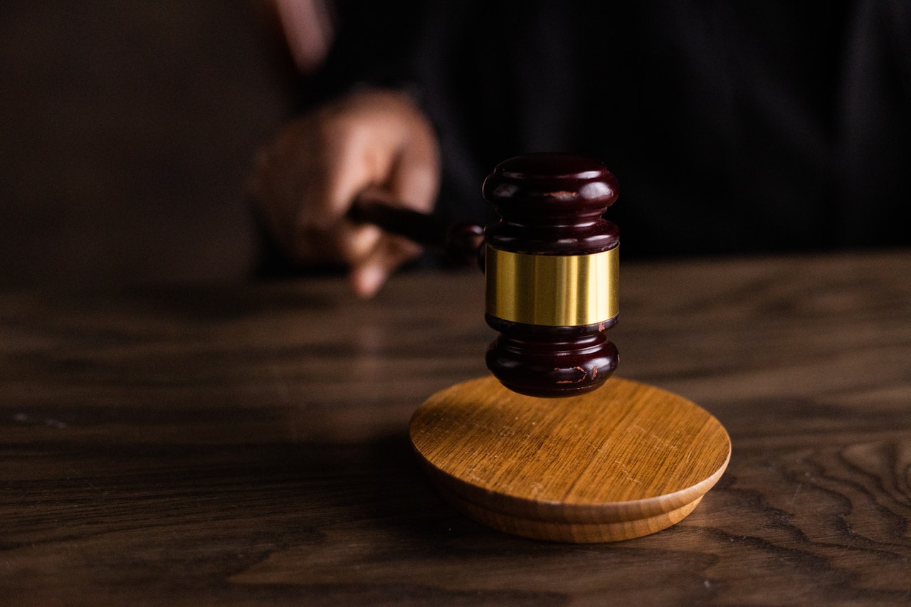 close up of man using brown wooden gavel